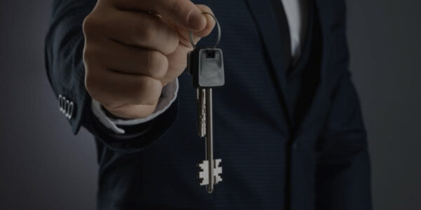 man-in-business-suit-holds-out-the-keys-in-his-hand-the-concept-of-realtor-mortgage-your-house-home-loan-copy-space-scaled-e1615088557326